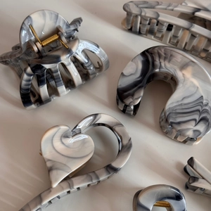 Close-up of gray ink marble acetate hair claws with premium glossy texture and patterns
