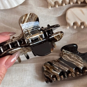 Detailed close-up of marble pattern acetate hair claw clip showing polished texture