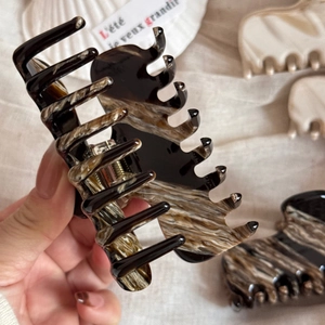 Detail view of tortoiseshell acetate hair claw with marble pattern and metal spring