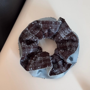 Detailed view of blue satin and brown plaid tweed patchwork hair scrunchie texture