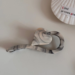 Detail of heart-shaped marble hair claw clip with smoke gray acetate ink patterns