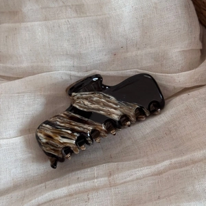Detail of French acetate hair claw clip with elegant black and tortoiseshell marble patterns