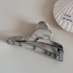 Detail shot of smoky grey ink wash marble pattern hair claw clip with heart shaped handle