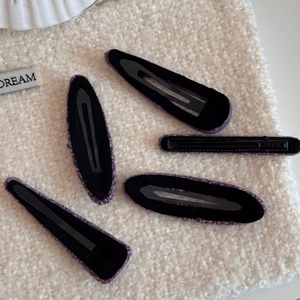 Juego de cinco pinzas para el cabello de tweed morado con formas variadas sobre lana blanca