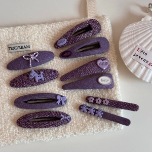 Detalle de set de horquillas moradas con lazos de lunares y tejidos de tweed