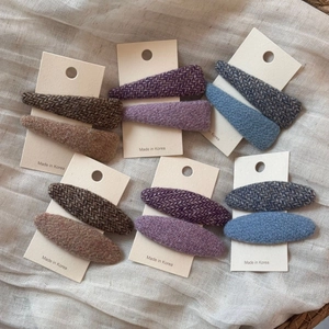 Set di fermagli per capelli colorati in tweed di forme triangolari e ovali su carta