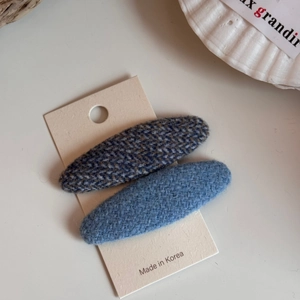 Dettaglio di fermagli per capelli BB in tweed colorato su carta in stile minimalista
