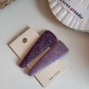 Dettaglio macro di fermagli per capelli in tweed viola su cartoncino per styling laterale