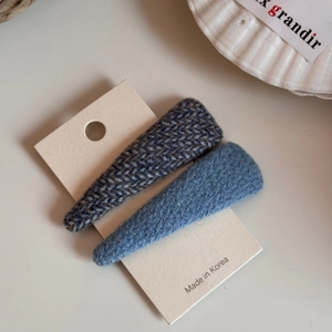 Dettaglio di fermagli per capelli BB in lana blu con motivo a spina di pesce