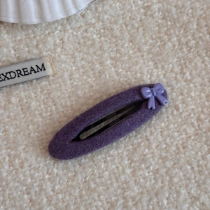 Detalle de una pinza para el pelo BB de punto morado con pequeño lazo de lunares