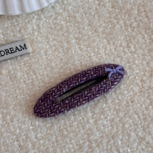 Primer plano de pasador para el cabello en tela de espiga violeta con un pequeño lazo