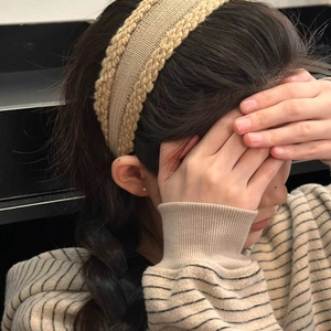 Close-up of beige cable-knit headband showing soft braided texture and elastic fabric