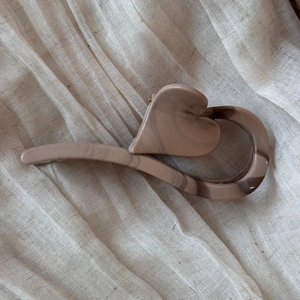 Detail of heart-shaped marble acetate hair claw clip with brown ink texture