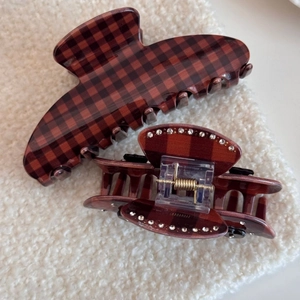 Detail view of retro brown gingham hair claws with sparkling rhinestone accents on boucle fabric