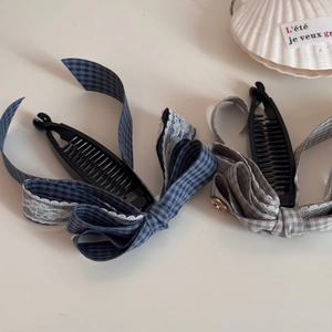 Détail de pinces à cheveux banane avec ruban à carreaux bleu et gris et dentelle