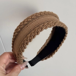 Detailed view of the chunky knit twist headband in brown with non-slip black lining