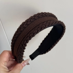 Detailed macro view of dark brown knitted headband texture with black inner lining