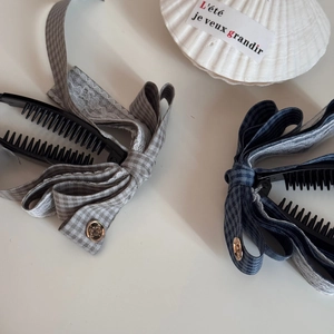 Détail de pinces banane à nœud à carreaux avec dentelle et boutons dorés vintage
