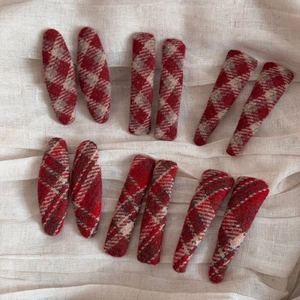 Detail view of 12 red plaid fabric hair clips in oval, square, and teardrop shapes