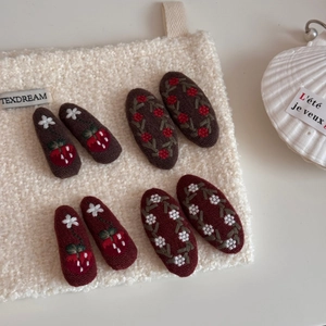 Detail of embroidered fabric strawberry BB clips and floral hairpins on soft velvet