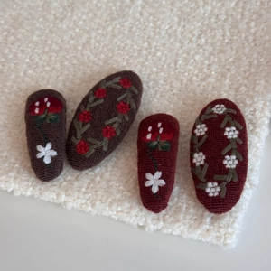 Detailed embroidery of daisies and mushrooms on vintage fabric snap hair clips