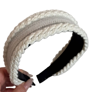 White knitted wide headband featuring a stylish twisted cable pattern for winter fashion