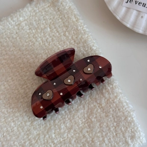 Detail of cocoa brown checkered hair claw clip with rhinestones and heart accents