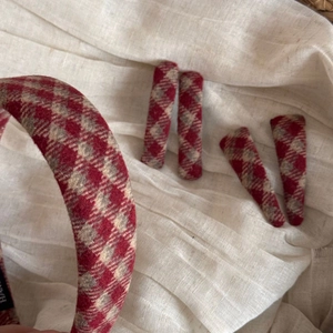 Close-up of red plaid tweed hair clip and sponge headband with vintage texture