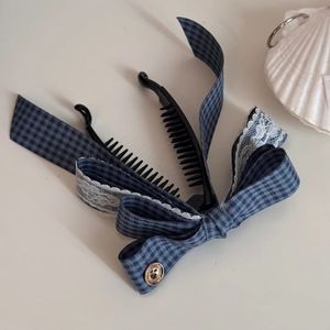 Détail de la pince à cheveux à nœud vichy bleu avec dentelle blanche et bouton doré