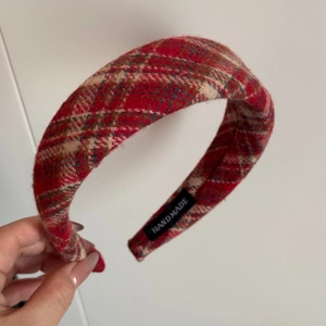 Detail of handmade red plaid tweed headband with inner label showing craftsmanship