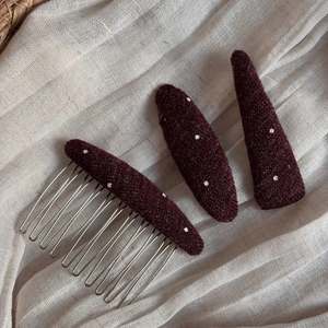 Polka dot fabric hair comb and clips set on a neutral linen background detail