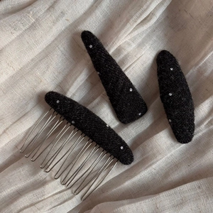 Close-up of black fabric hair clips with white polka dots and soft felt texture