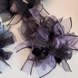 Detail of layered organza hair scrunchie with purple bow and black lace edges