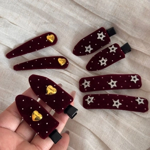 Detailed macro view of burgundy velvet hair clips with polka dots and sparkling star charms