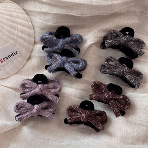 Detailed macro view of knitted tweed bow hair clips in multiple elegant colors