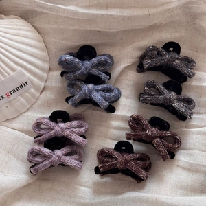 Knitted bow hair claw clips set in blue, grey, purple and brown on linen background