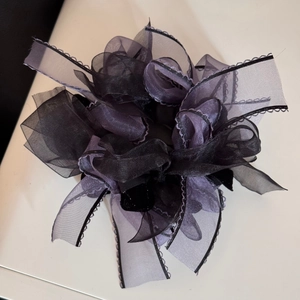 Detail of multi-layered tulle bow scrunchie with delicate wavy edges and bicolor design