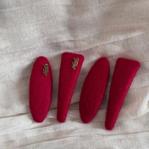 Close-up of red felt hair clips set featuring gold Handmade metal letter ornaments
