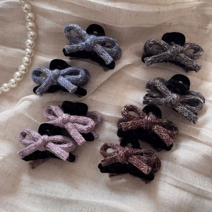 Set of 8 wool bow hair clips in assorted autumn colors on soft textured fabric