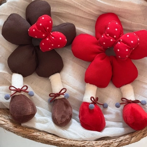 Détail d'accessoires floraux en peluche avec nœuds à pois dans un panier tressé
