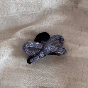 Detail of Korean-style mixed-blue knit bow hair claw clip with texture on linen fabric