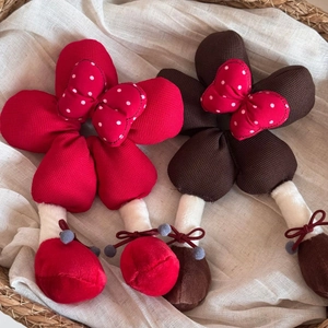 Chouchou fleur en peluche avec nœud à pois rouges présenté dans un panier tissé
