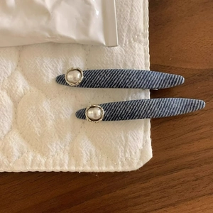 Blue striped denim hair clips with pearls on a soft quilted fabric background