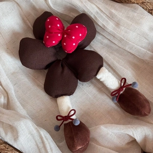 Détail d'un chouchou en peluche style Minnie avec nœud à pois et jambes suspendues