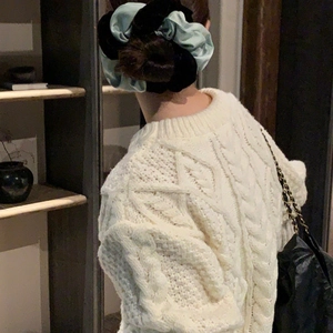 Detail view of oversized mint green and black scrunchie on a ponytail with knitwear
