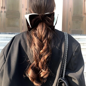 Detail view of large brown velvet bow clip on model for an elegant hair accessory look