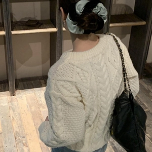 Detail of mint chocolate scrunchie styled with a cream knit sweater and black chain bag