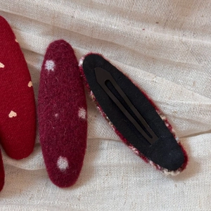 Detail of red fabric BB hair clips with heart and polka dot patterns on mesh fabric