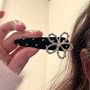 Detailansicht der gepunkteten Haarspange mit silberner Blume und funkelndem Strassstein