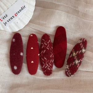 Detailed view of red fabric hair clips with polka dots and heart patterns for hair styling